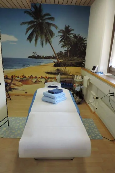 Behandlungsraum mit Palmenstrand-Wand bei Relax in Frauenfeld